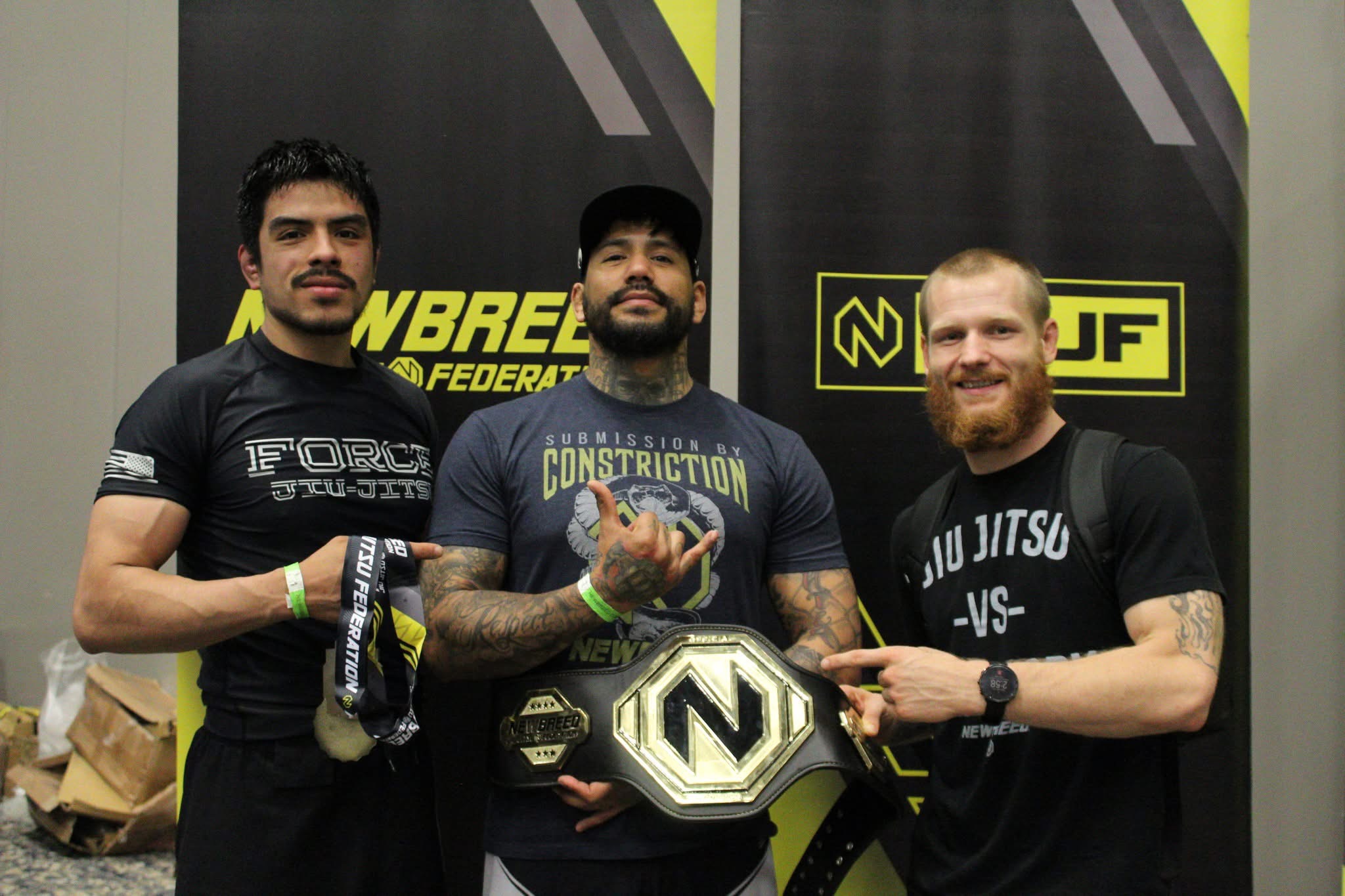 Wyatt Montgomery, Andres Lazcano, and Chris Martinez with a championship belt